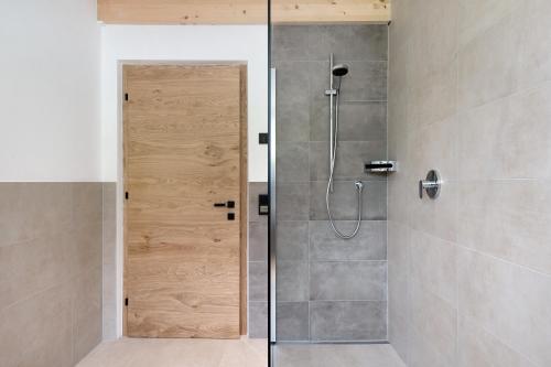 a shower with a glass door in a bathroom at Daunëihof in Selva di Val Gardena