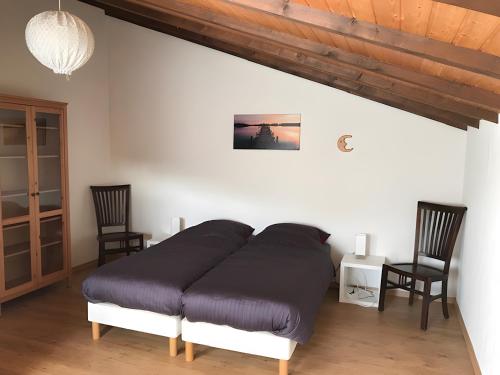 a bed in a room with two chairs at Am Trapp in Padberg