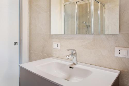 a bathroom with a white sink and a mirror at Appartamento Gaia in Caspoggio