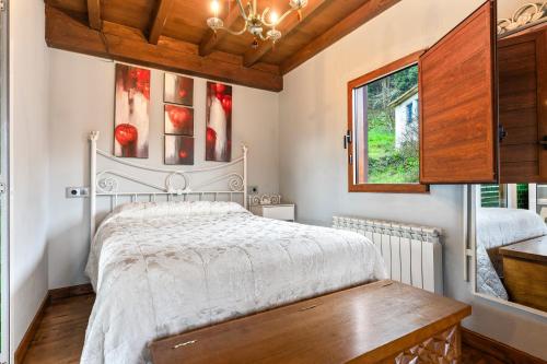 a bedroom with a white bed and a window at La Manzana in Candamin
