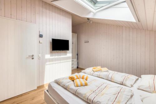 two beds in a white room with a skylight at Ferienhaus Manni Dg in Büsum