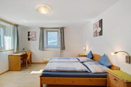 a bedroom with a bed and a desk in it at Nagelehof in Ridanna