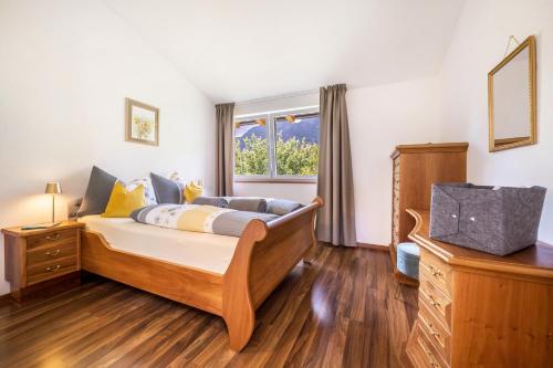 a bedroom with a bed and a window at Angerblick Apartment in Appiano sulla Strada del Vino