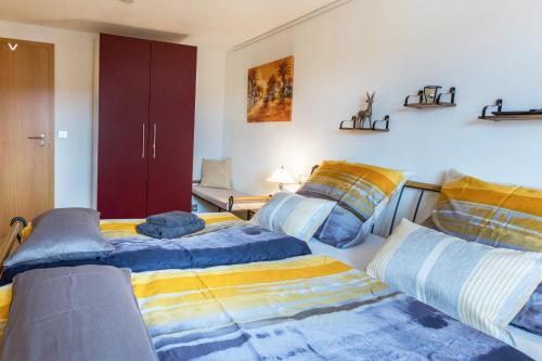 a bedroom with two beds and a red cabinet at Schwarzwaldblick in Sankt Georgen im Schwarzwald