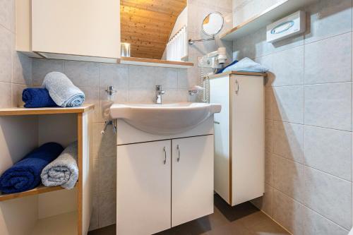 a bathroom with a sink and a mirror and towels at App Sonnenschein - Duregger in Campo Tures