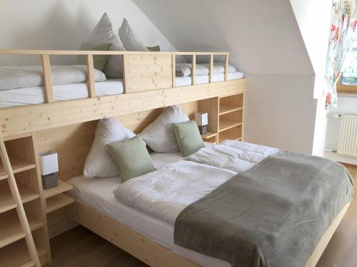 a bedroom with a bunk bed with white sheets and pillows at Ferienwohnung Immenberg in Dirlewang