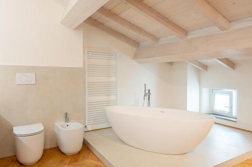 a bathroom with a large white tub and a toilet at Casa Cennano in Montevarchi