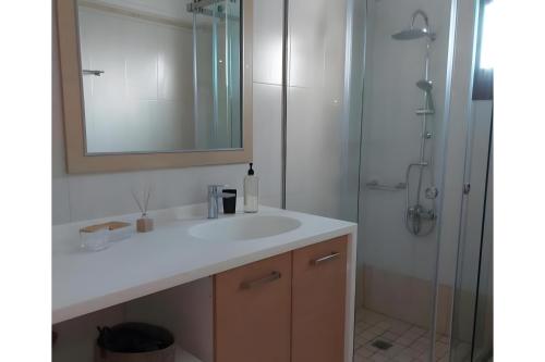 a bathroom with a sink and a shower with a mirror at Beach front Villa Pasithea in Monolithos