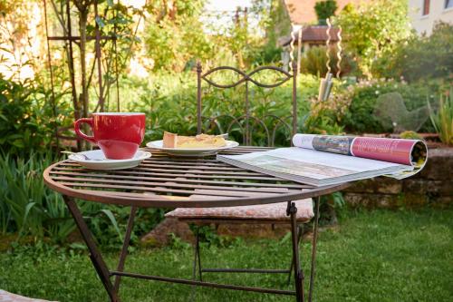 a table with a cup and a plate of food on it at Winzercafé Neipperg in Brackenheim