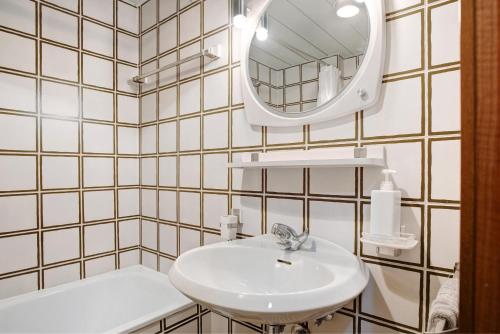 a white bathroom with a sink and a mirror at Appartamento Nives in Marilleva