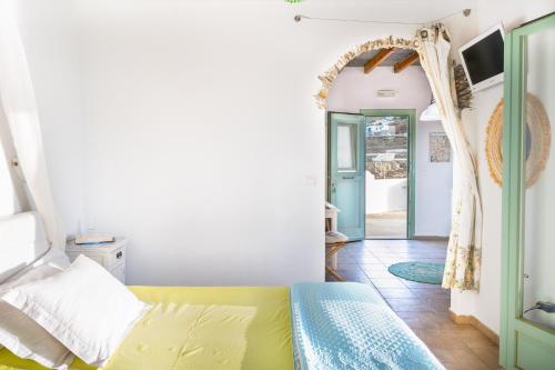 a bedroom with a bed and an open doorway at Paros - Sikinos Sunset in Sikinos