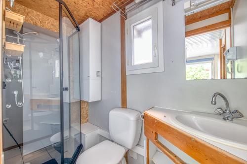 a bathroom with a shower and a toilet and a sink at Chalet B Village Vacances in Gujan-Mestras