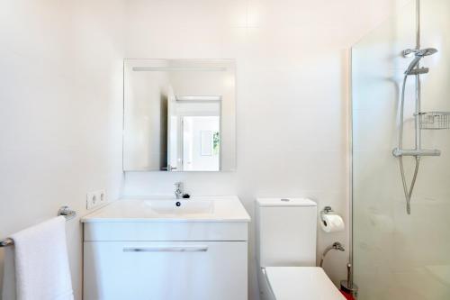 a white bathroom with a sink and a toilet at Es Cos in Algaida