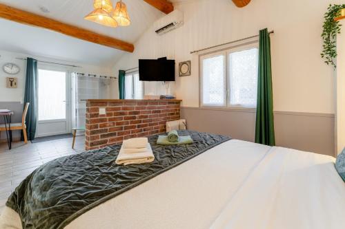 a bedroom with a large bed and a brick wall at La Petite Maison in Bédoin