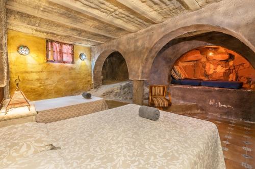 a bedroom with a bed and a tub in a room at Casa Rural Ermita de las eras in Algarinejo