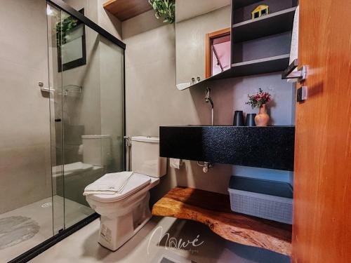 a bathroom with a toilet and a glass shower at Apartamento Verano pé na areia em tatuamunha - NSUN105 in Pôrto de Pedras
