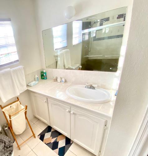 a white bathroom with a sink and a mirror at Cool Stay in Christ Church