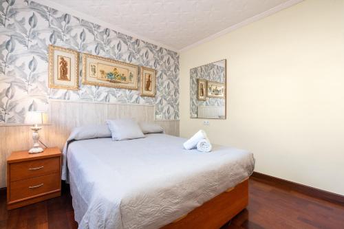 a bedroom with a bed and a dresser with a night stand at Casa Thaiker in Miami Platja