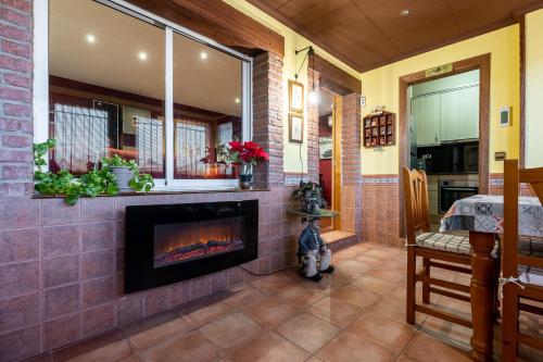 a living room with a fireplace and a kitchen at Casa Thaiker in Miami Platja