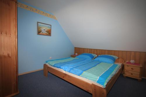 a bedroom with a wooden bed with blue sheets at Ferienwohnung 'auf dem Burstel' in Kleines Wiesental