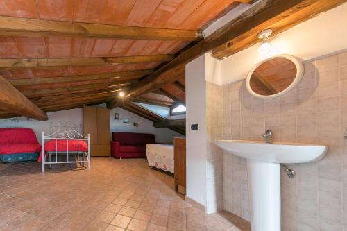a bathroom with a sink and a bedroom at Stupendo rustico in pietra in Castellina Marittima