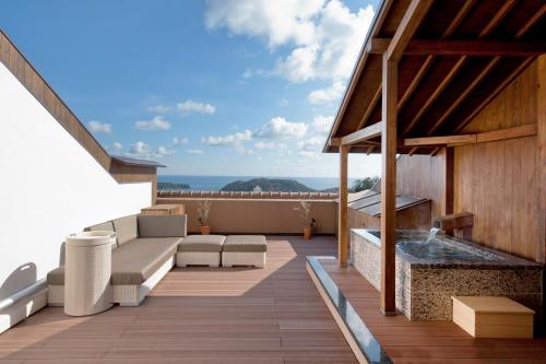 a deck with a couch and a fireplace on a house at Toba Ocean Resort All-Inclusive Hotel in Toba