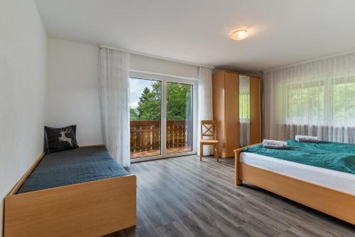 a bedroom with two beds and a large window at Fuchsmichelhof 4 in Seebach