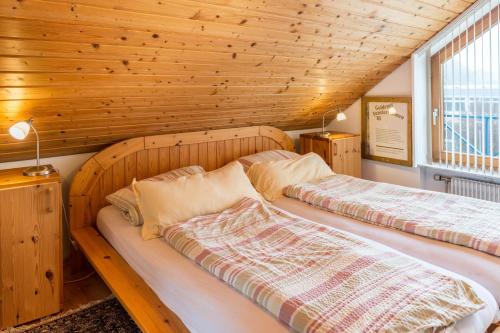 two beds in a room with a wooden ceiling at Ferienwohnung Schlegel in Singen