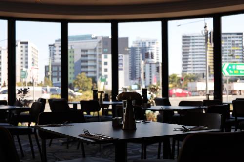 a restaurant with tables and chairs and a view of a city at Hotel Kingsley in Brisbane