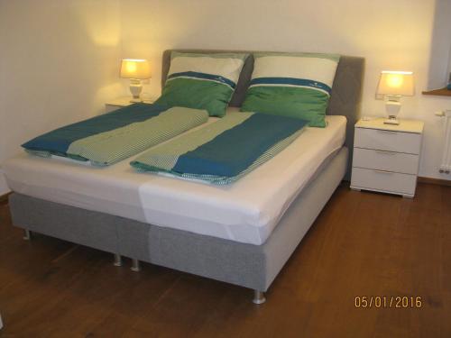 a bed with two pillows on it with two lamps at Damkröger 2 Inselwohnung - Seeblick in Lindau