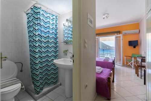 a bathroom with a sink and a toilet and a room at Apostolos Apartment 3 in Póndi