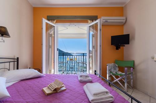 a bedroom with a purple bed with a view of the ocean at Apostolos Apartment 3 in Póndi