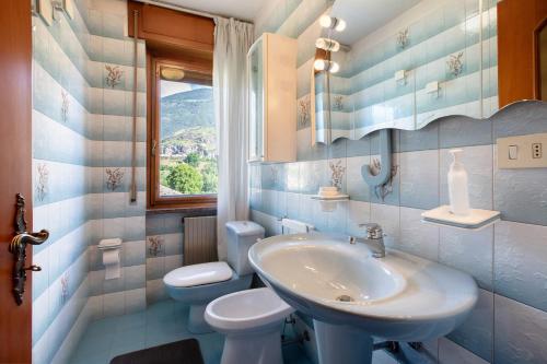 a bathroom with a sink and a toilet and a window at Casa Lella Clemy in Aymavilles