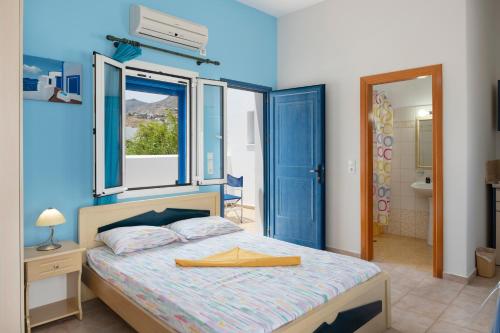 a bedroom with a large bed and a bathroom at Studios Ninemia Serifos 2 in Livadi