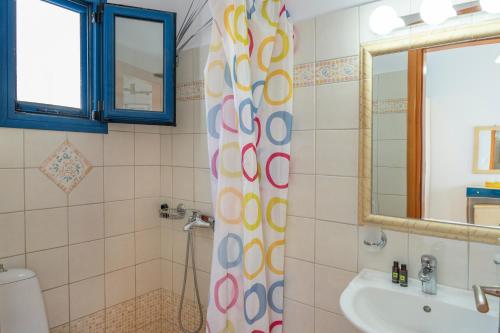a bathroom with a shower curtain and a sink at Studios Ninemia Serifos 2 in Livadi
