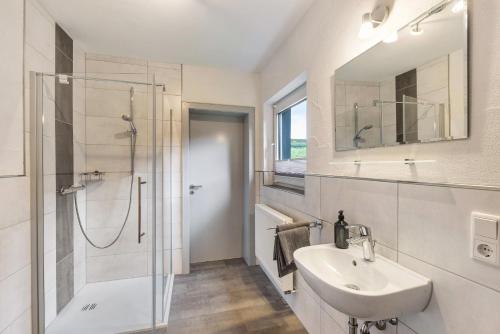 a white bathroom with a sink and a shower at Ferienwohnung Christel in Schmallenberg