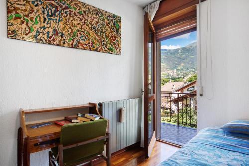 a bedroom with a desk and a bed and a window at Casa Lella Clemy in Aymavilles