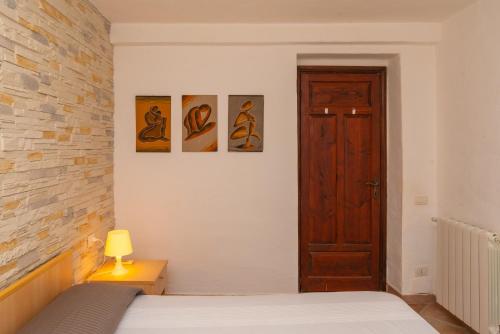 a bedroom with a bed and three pictures on the wall at Appartamento del Pellicano in Olbia