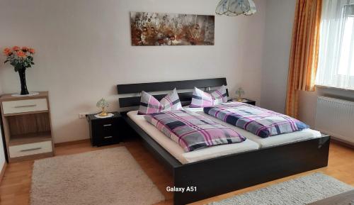 a bedroom with a bed with pink and purple pillows at Haus Broni in Prem