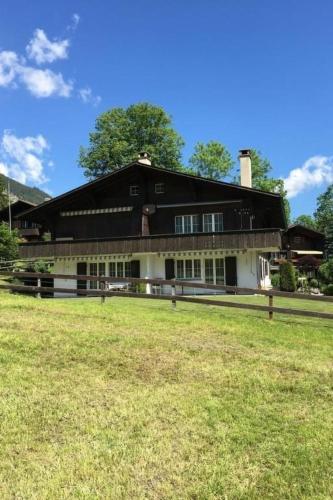 a large building with a grass field in front of it at Apartment Chalet Steinbock by Interhome in Lenk