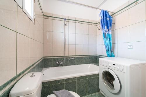 a bathroom with a washing machine and a washer at Panorama House Petritis in Petrití