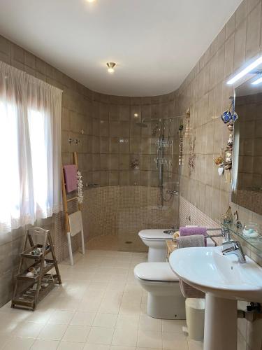 a bathroom with two toilets and a sink and a tub at Casa Vora Mar in Felanitx