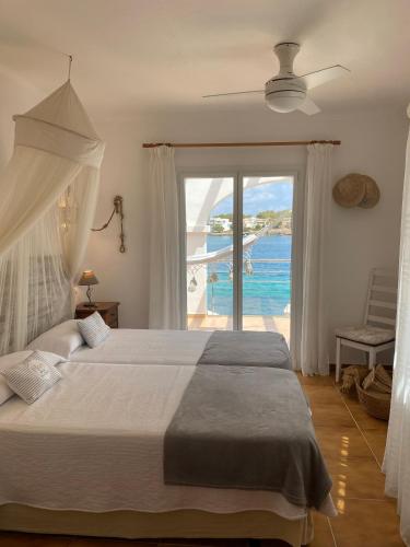 a bedroom with a bed with a view of the ocean at Casa Vora Mar in Felanitx