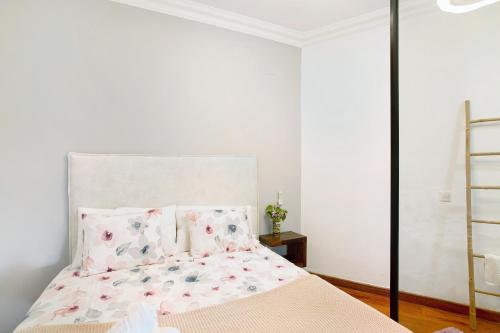 a bedroom with a bed with pink floral pillows at Carmelo y Carmela 2 in Teror