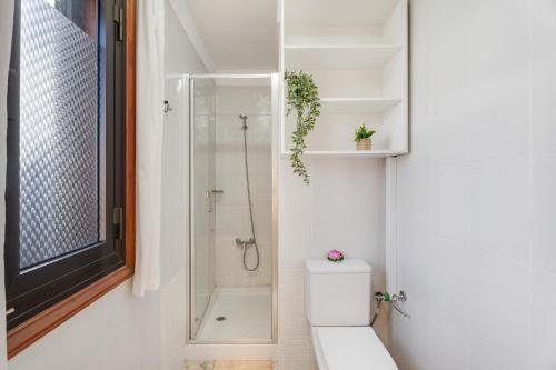 a white bathroom with a shower and a toilet at Atico cardon beach in Costa Adeje