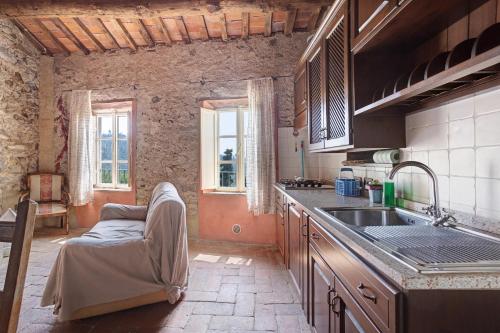 a kitchen with a sink and a couch in it at Villa Chelucci - Gualdo in Massarosa