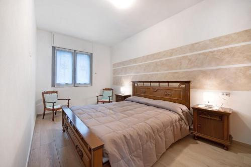 a bedroom with a large bed and two chairs at Casa Tovini in Pisogne