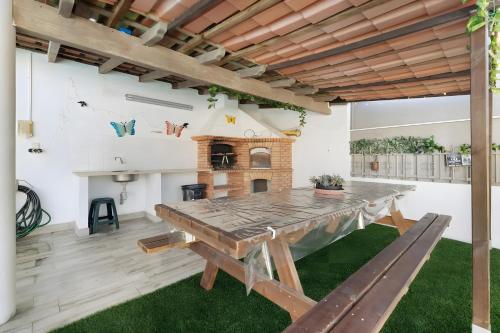 a dining room with a wooden table and a fireplace at Villa As Cumadres in Azeitao