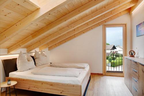 a bedroom with a bed and a large window at Alpenloft Meditz in Unterammergau