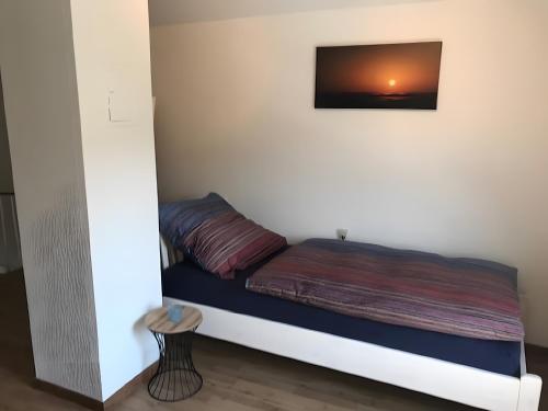 a bed in a room with a picture on the wall at Ferienhaus Am Fulda Ufer in Rotenburg an der Fulda